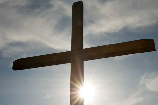 Kreuz vor sonnigem Himmel